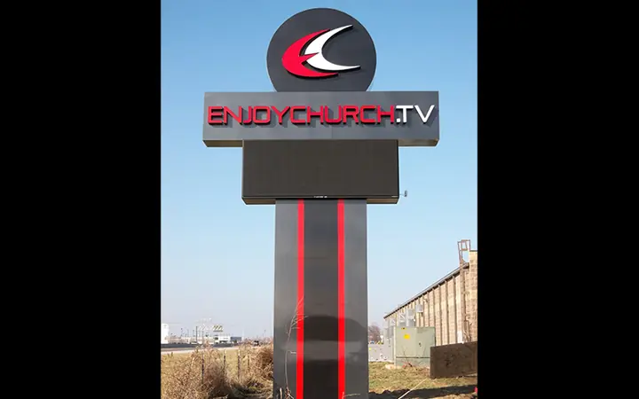 EnjoyChurch.TV pylon sign with halo-lit lettering above an LED message center