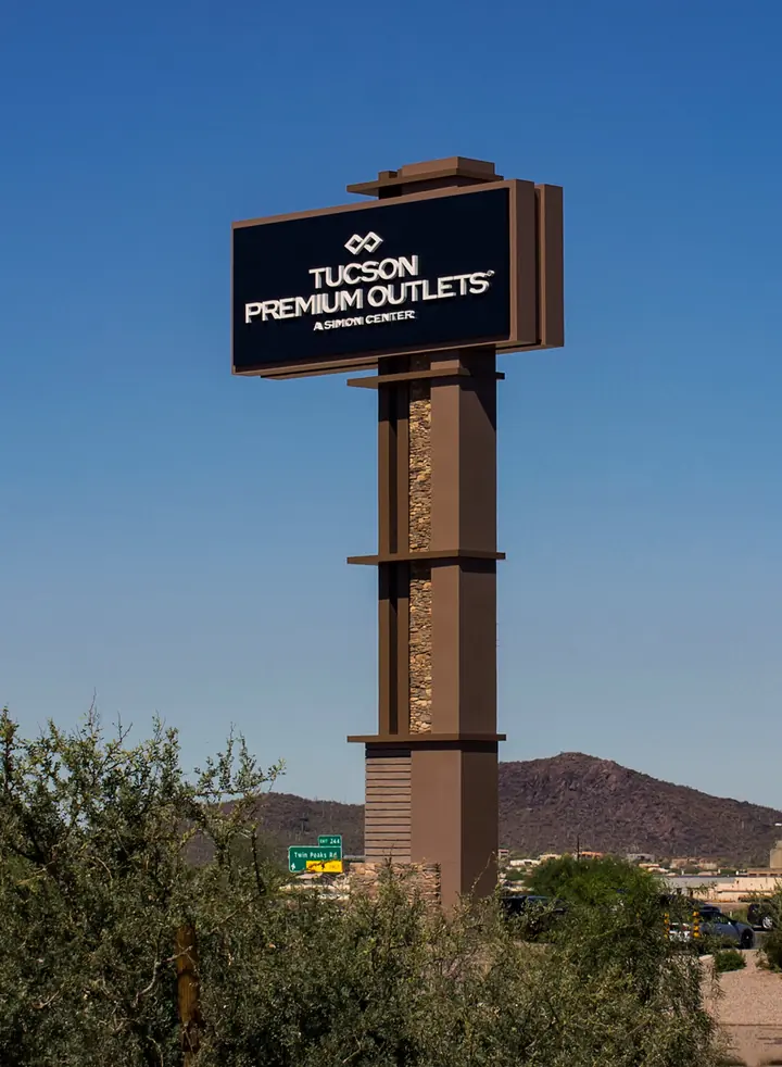 Tucson Premium Outlets illuminated multi-tenant pylon sign on a stacked stone column