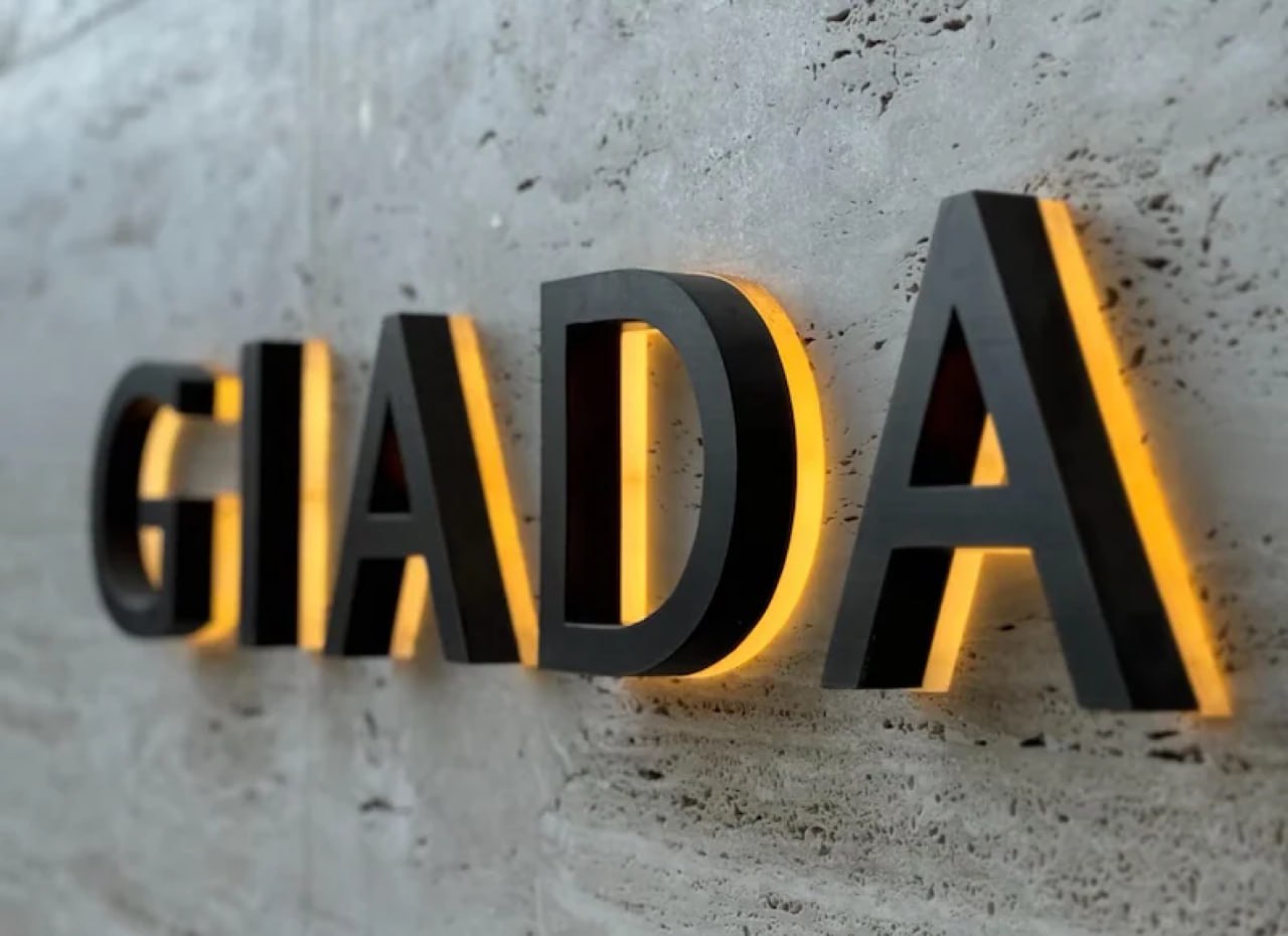 Giada halo-lit channel letters with warm white glow on a concrete wall
