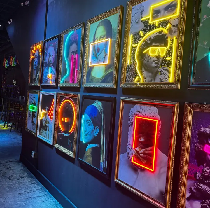 Wall of gold-framed neon art paintings at The Oyster Bar
