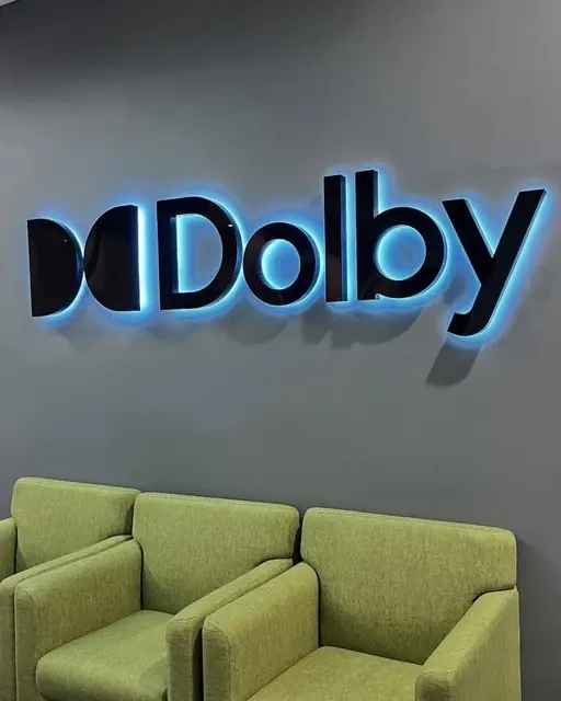 Dolby halo-lit reverse channel letters with blue glow on a lobby wall