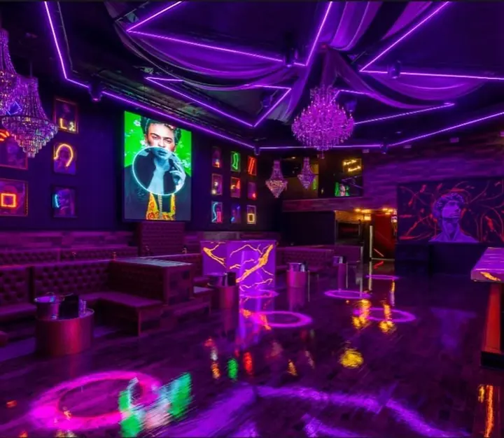 Framed neon art series on lounge walls at Galeria