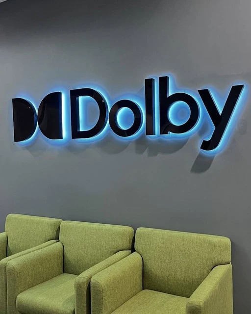 Dolby halo-lit reverse channel letters with blue glow on a lobby wall